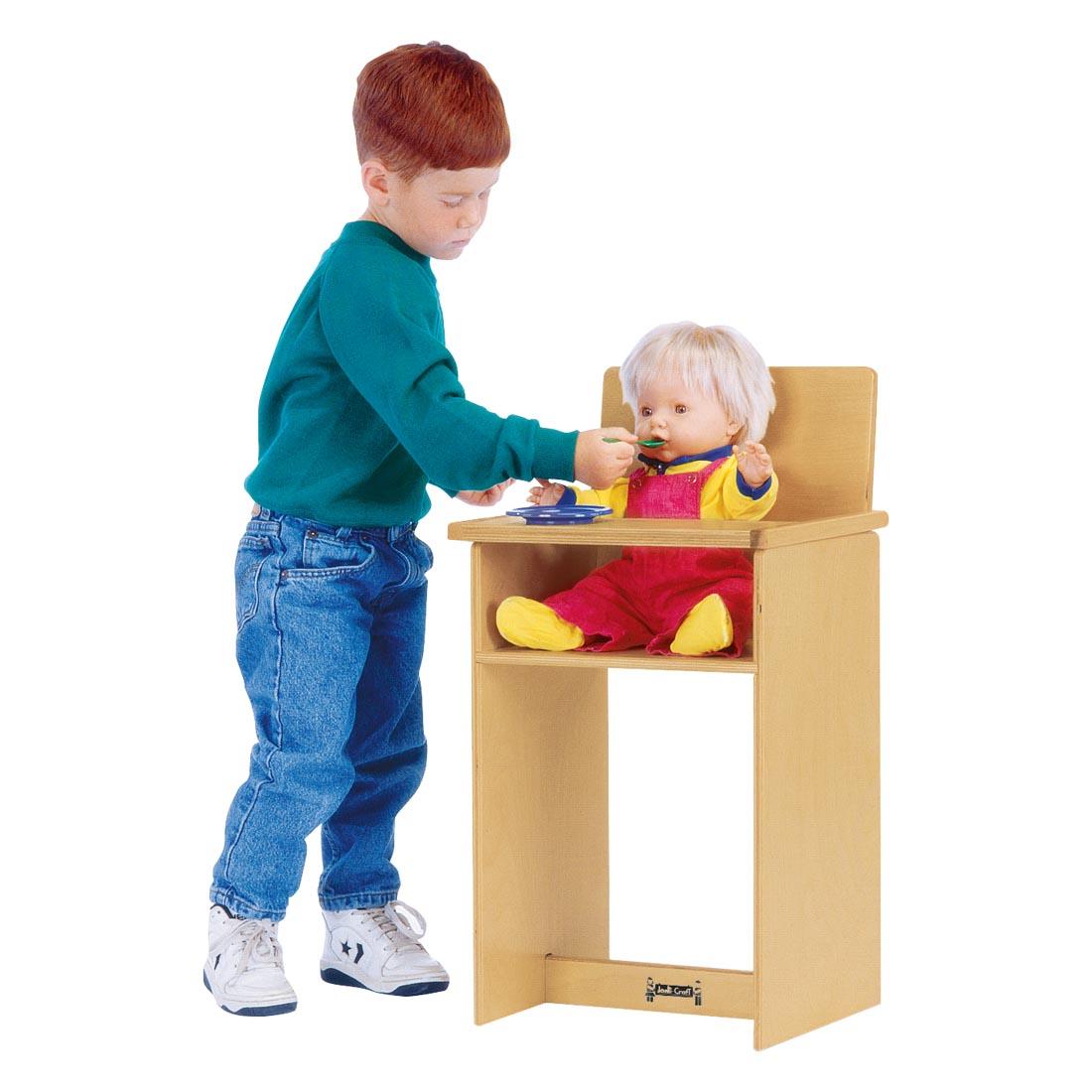 Child playing with the Doll High Chair