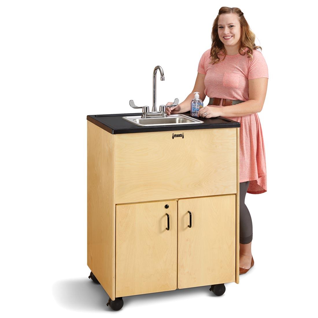 Adult standing at the Clean Hands Helper Portable Stainless Steel Sink