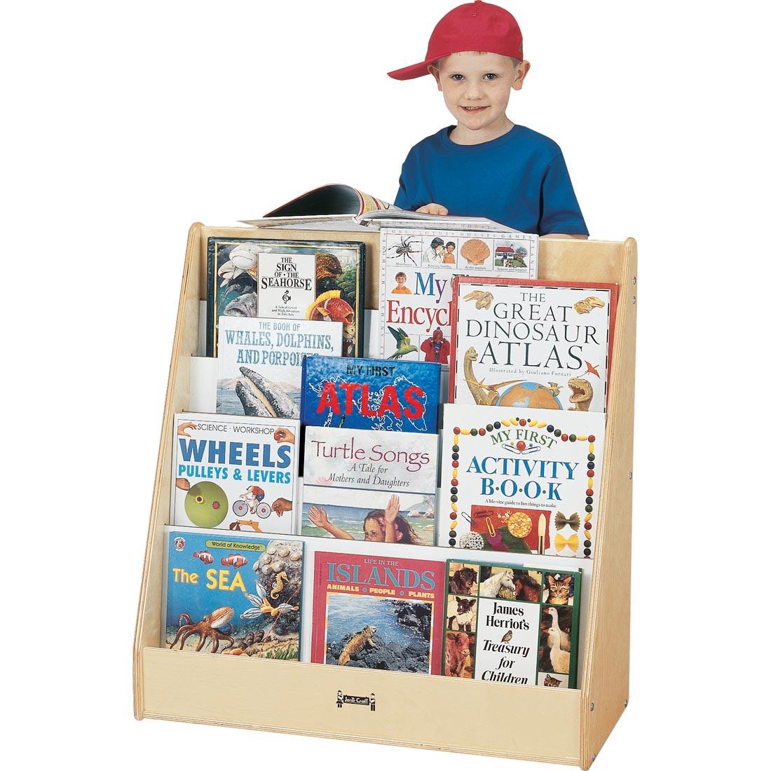 Child standing behind the Natural Birch Pick-a-Book Flushback Book Stand