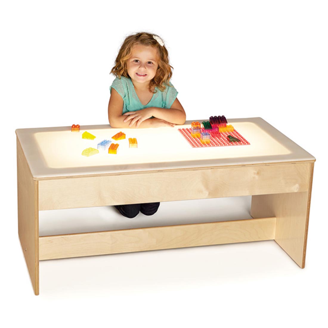 Child kneeling with building blocks at the Birch Light Table