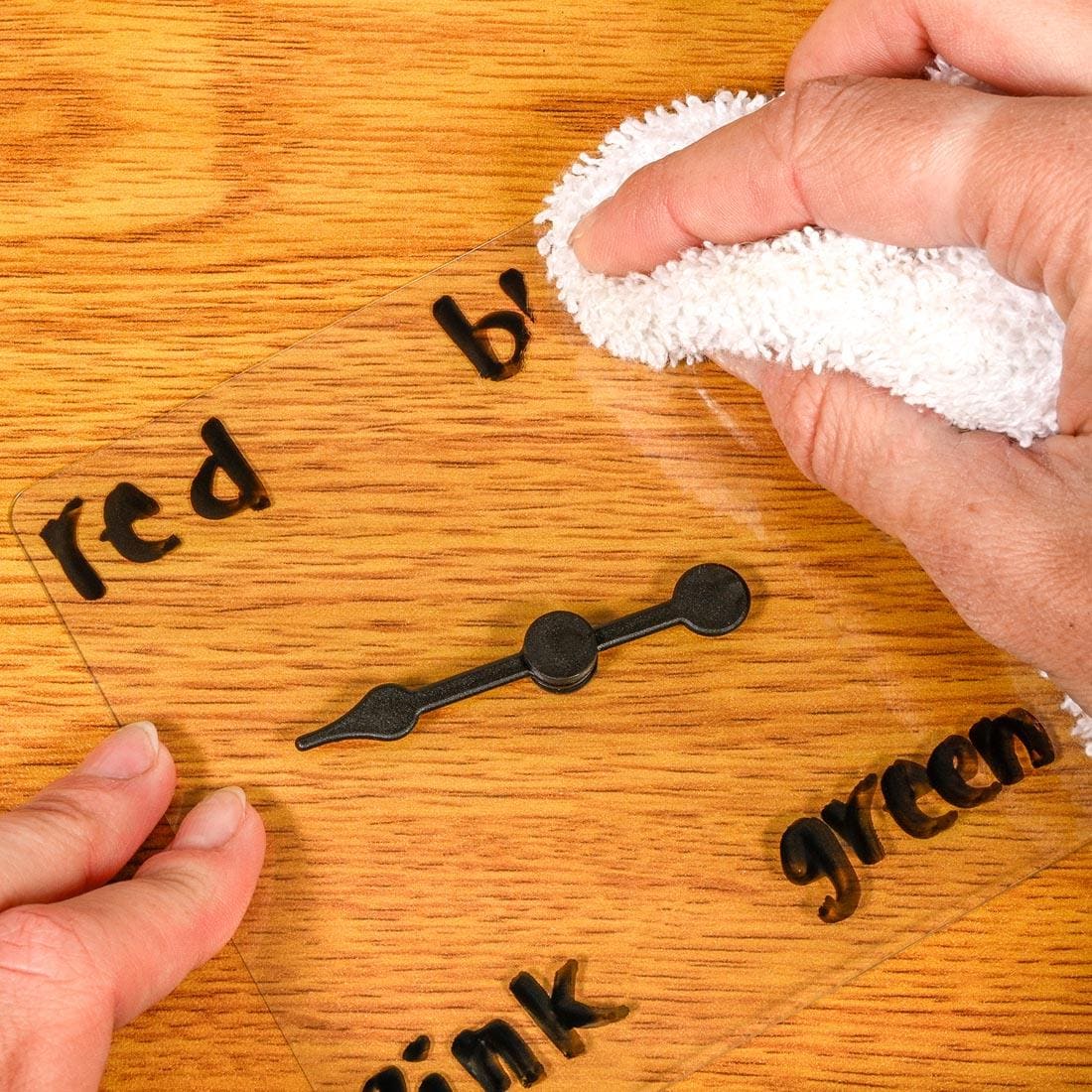 hands erasing writing from a Transparent Game Spinner