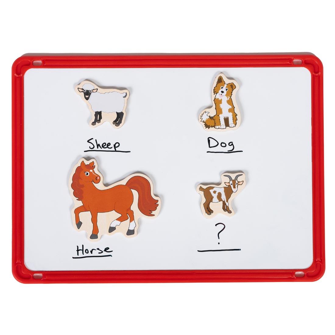 4 Farm Wooden Magnets By Learning Advantage on a whiteboard with their names written in marker