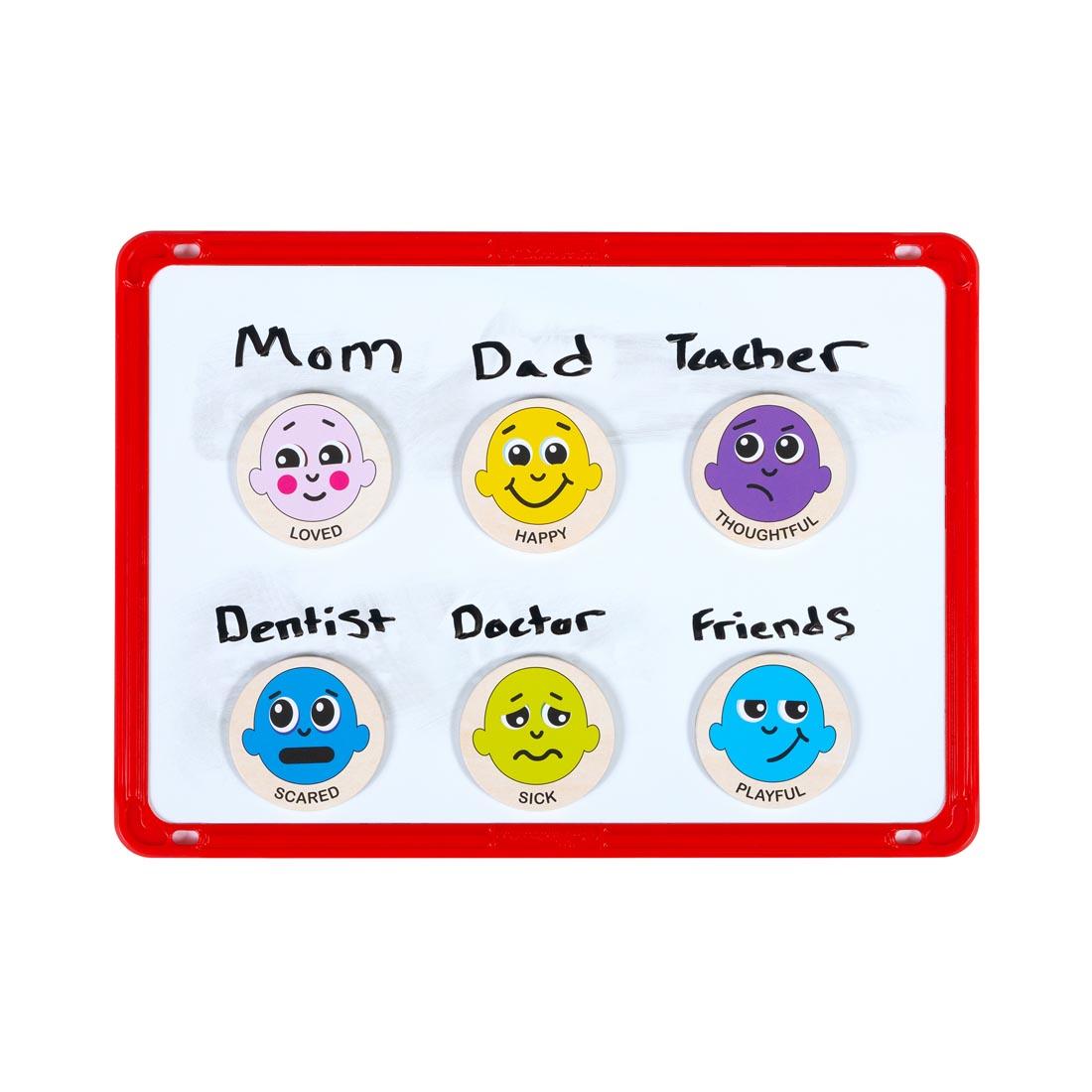 six different Emotions Wooden Magnets on a whiteboard labeled with names