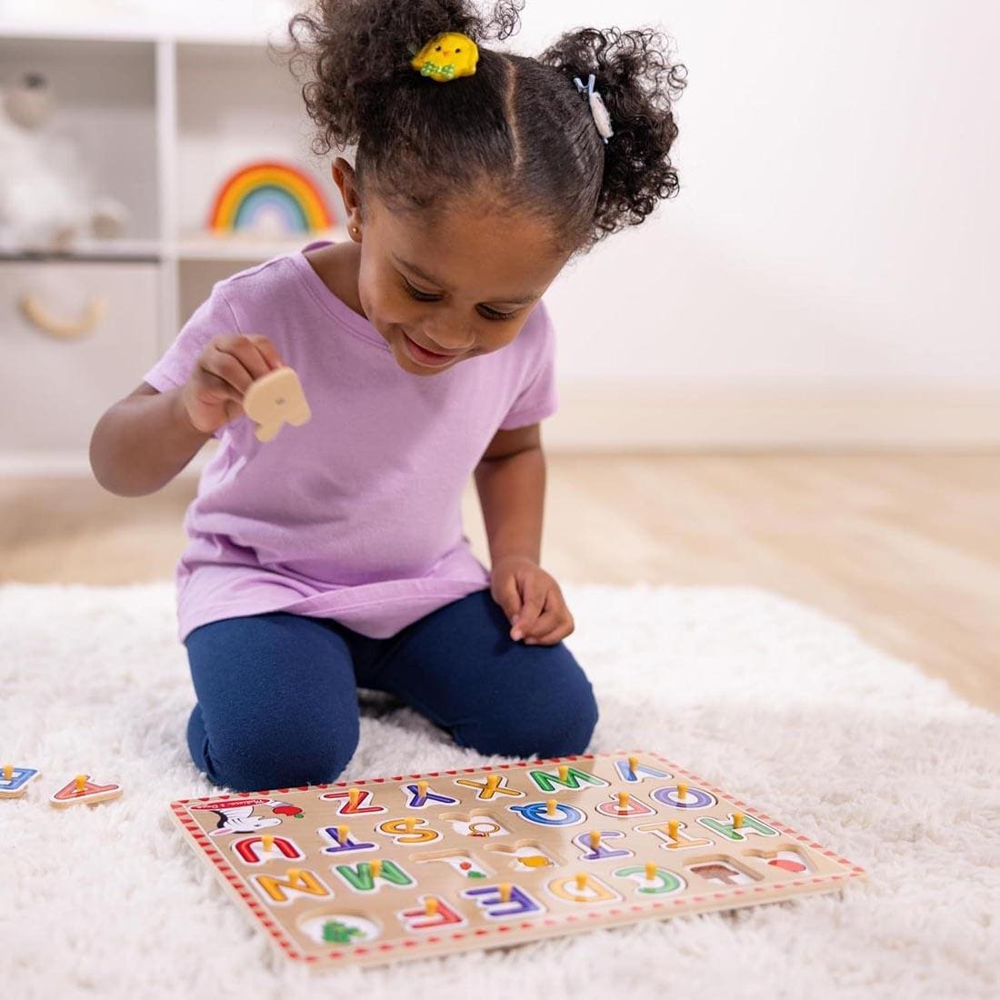 Young girl playing with Lift & See Alphabet Peg Puzzle
