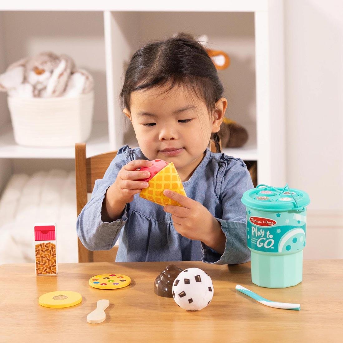 child playing with Play To Go Ice Cream Play Set By Melissa & Doug
