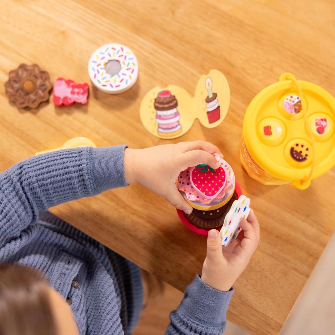 view from above of child playing with Play To Go Cake & Cookies Play Set By Melissa & Doug