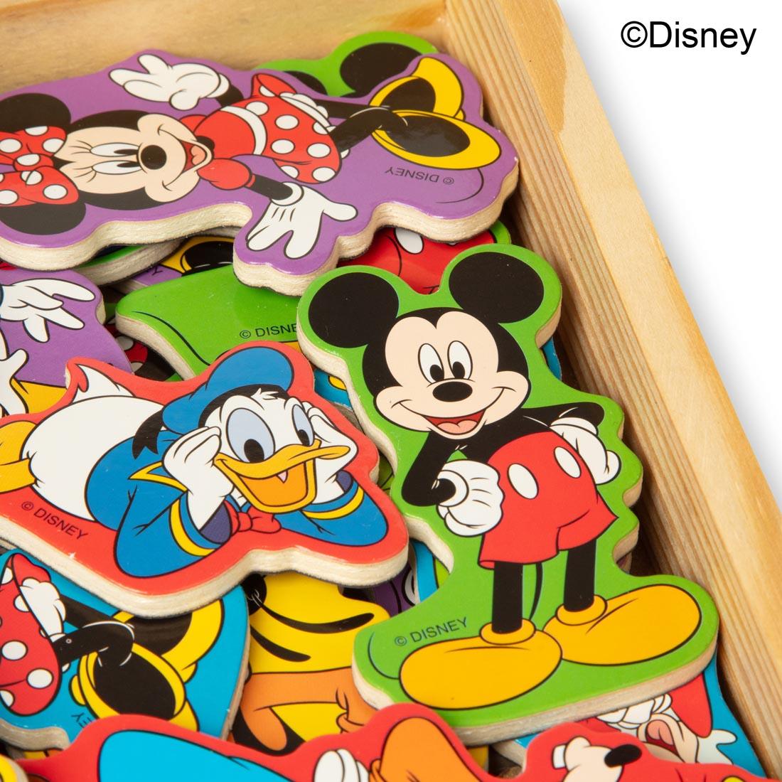 close up of several Disney character magnets, inside a wooden storage box