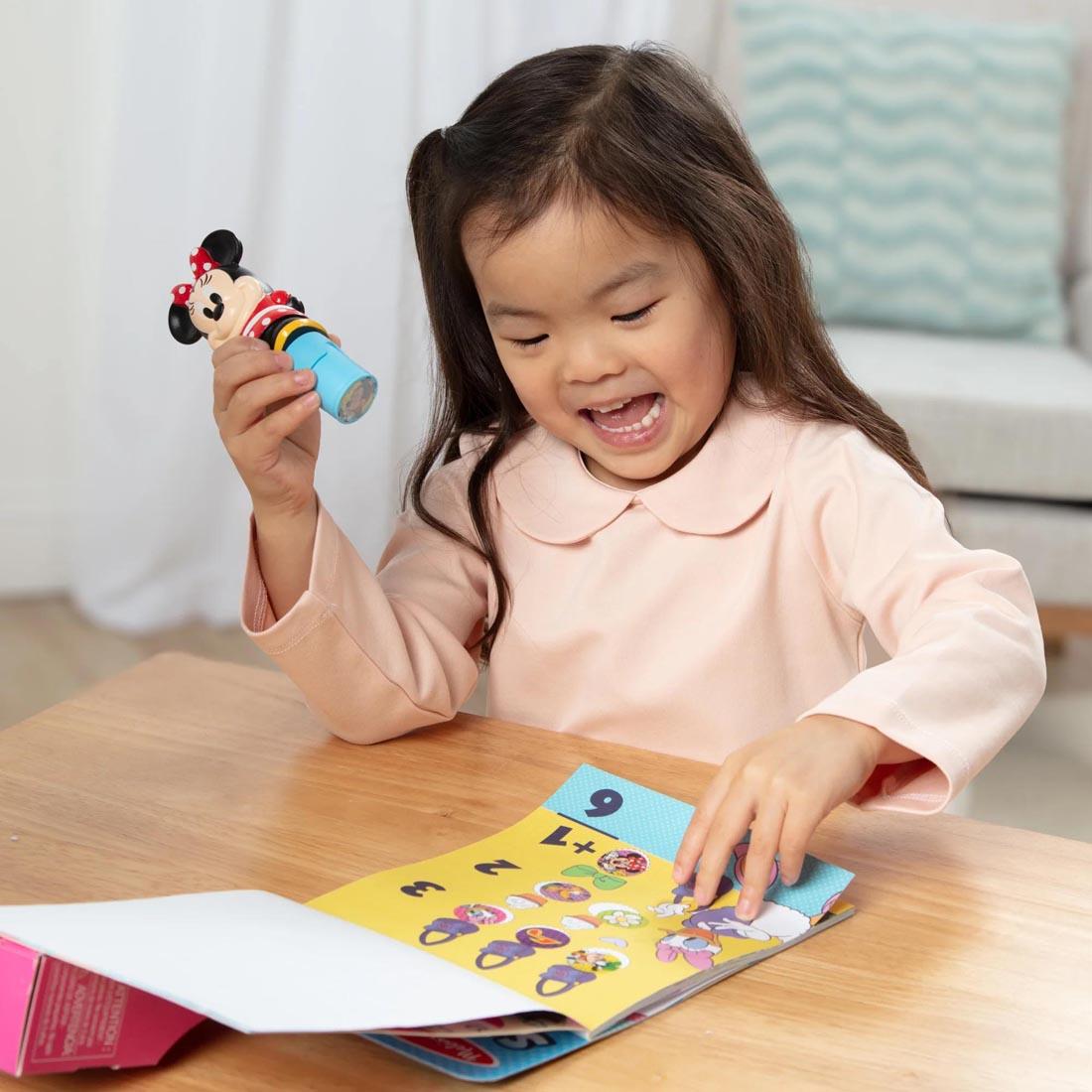 child using the Minnie Mouse Sticker Wow! Set By Melissa & Doug