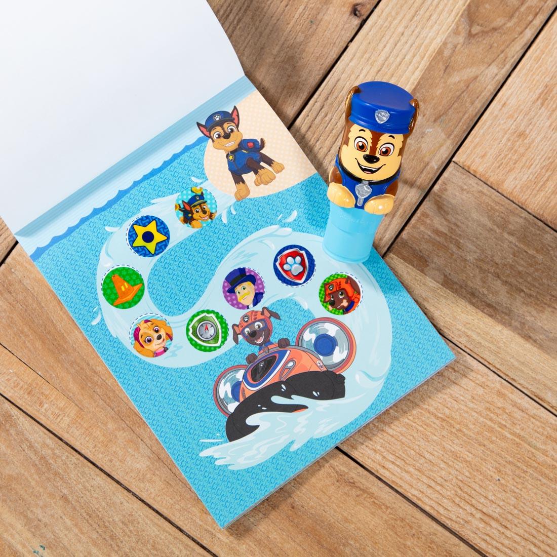 Paw Patrol Chase Sticker Wow! stamper, plus open activity book with several round stickers applied