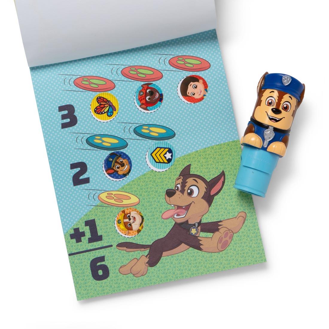 Paw Patrol Chase Sticker Wow! stamper, plus open activity book with several round stickers applied