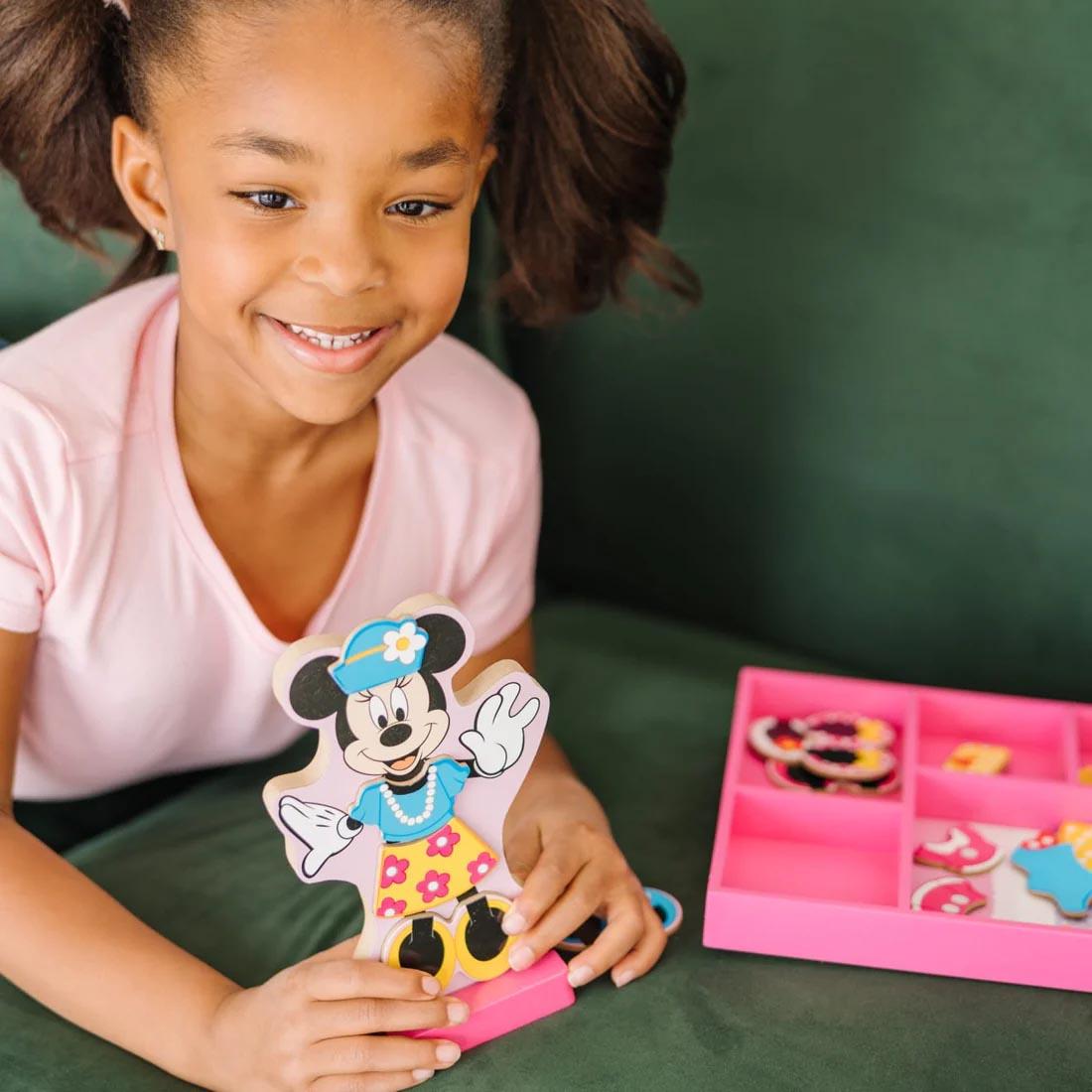 child playing with the Disney Minnie Wooden Magnetic Dress-Up Set By Melissa & Doug
