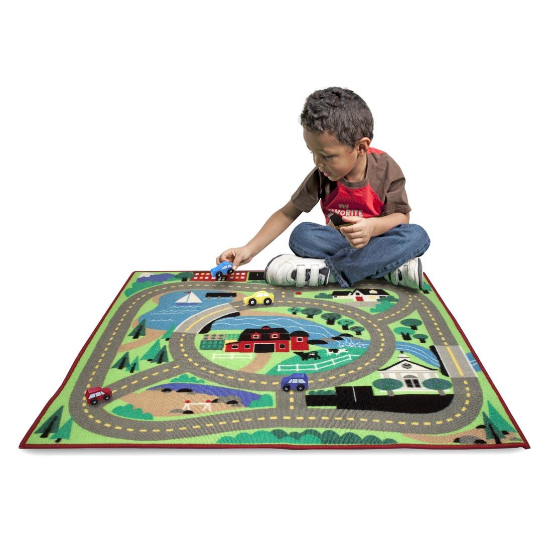 child playing with the Melissa & Doug Round the Town Road Rug & Car Set