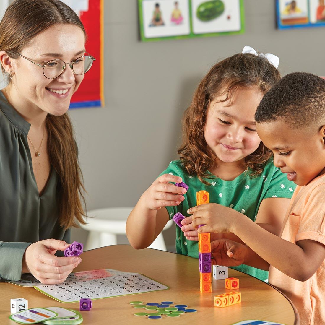 two children and an adult using the Skill Builders! Kindergarten Math Activity Set