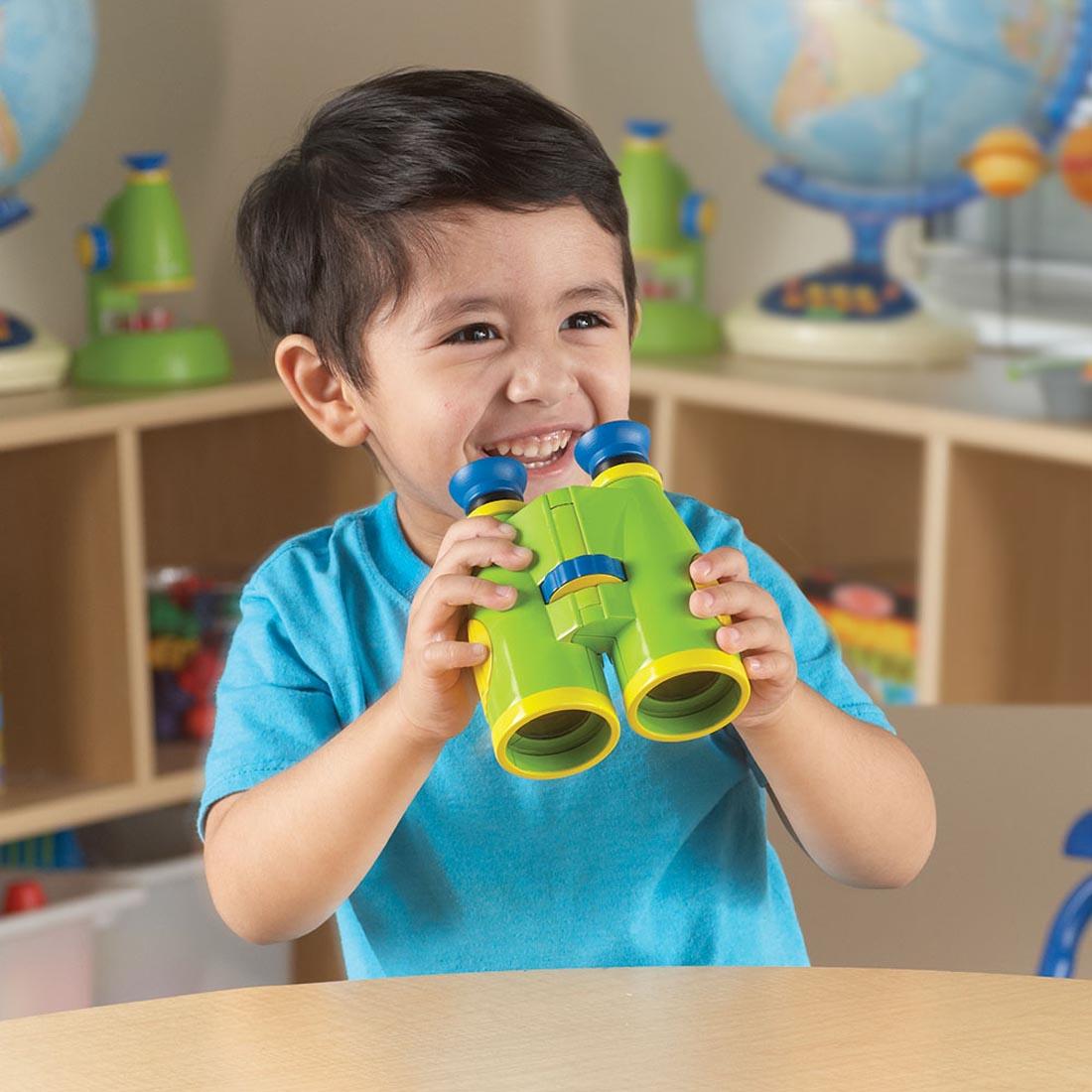 child holding the Primary Science Big View Binoculars By Learning Resources