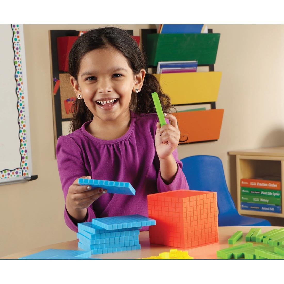 child holding pieces from the Base Ten Starter Set By Learning Resources