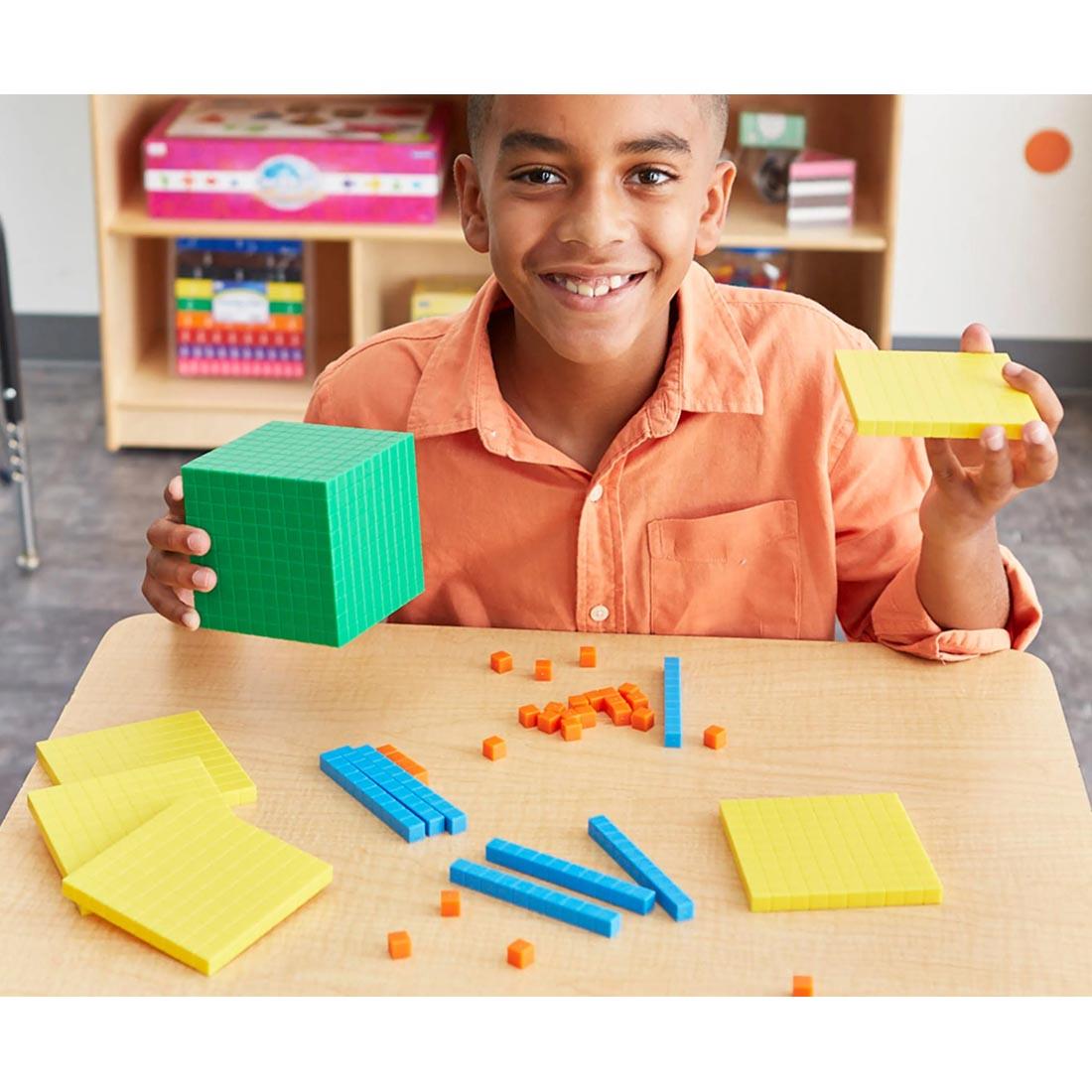 child holding pieces from the Base Ten Starter Set By Learning Resources