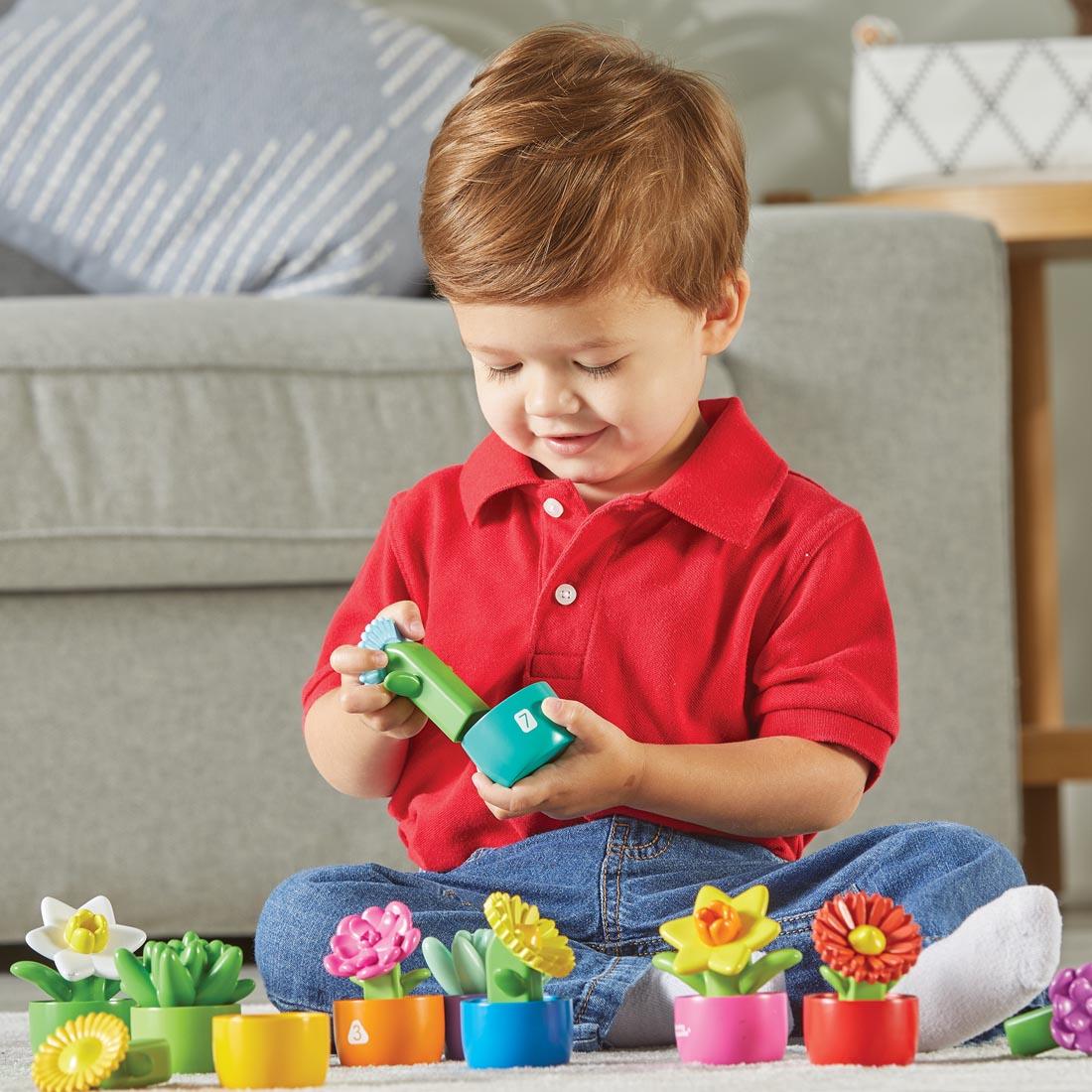 child sitting on the floor playing with the Shape & Color Garden by Learning Resources