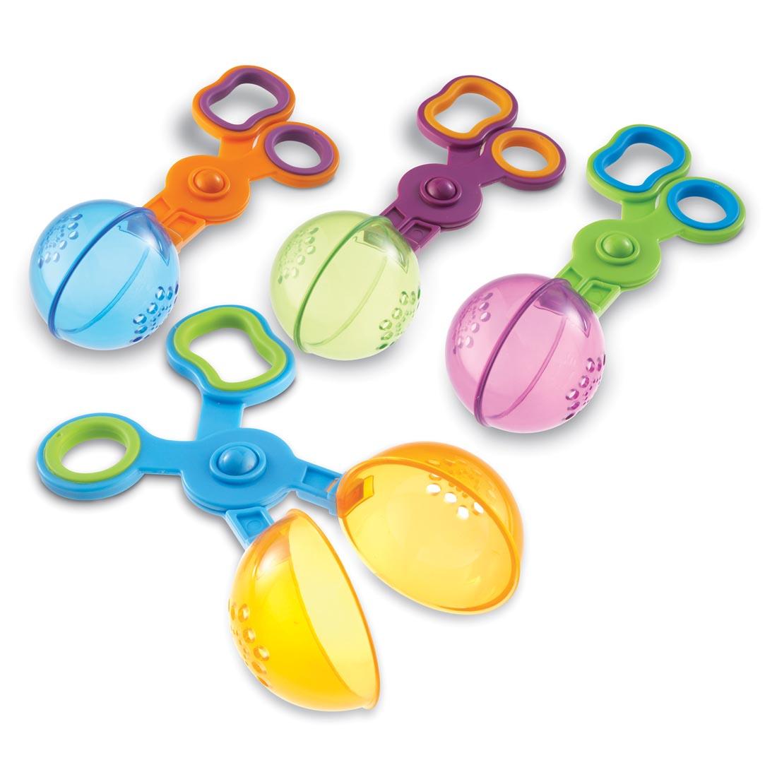 Four plastic ball scoopers with scissor-like handles