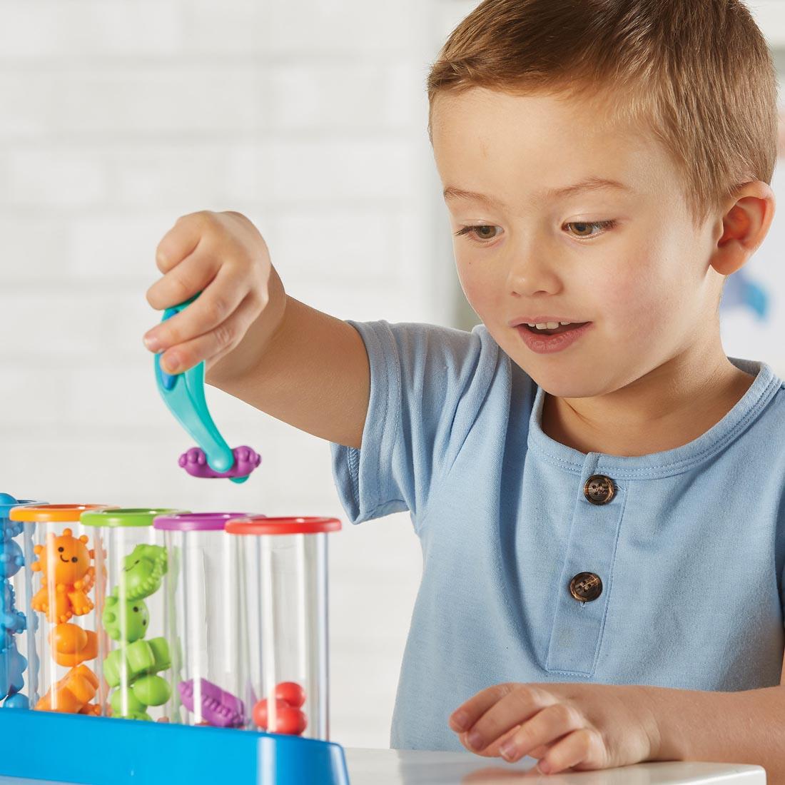 child using the test tubes and tongs from the Silly Science! Fine Motor Sorting Set By Learning Resources