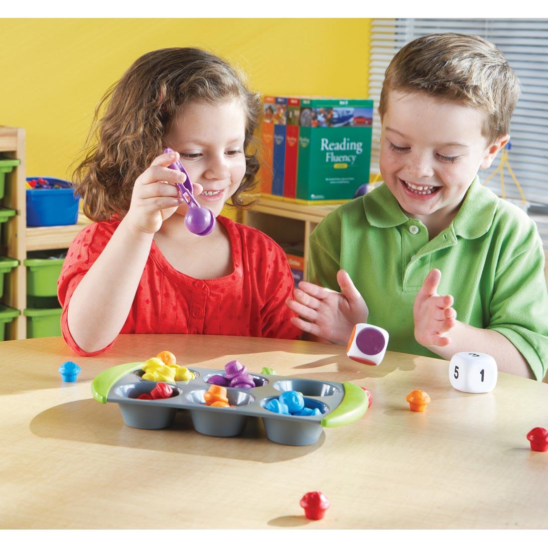 children rolling a colored die while playing Mini Muffin Match Up Set