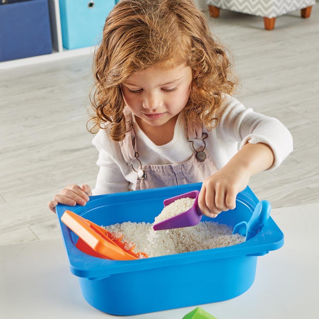 child using the Helping Hands Sensory Scoops with a bin of rice
