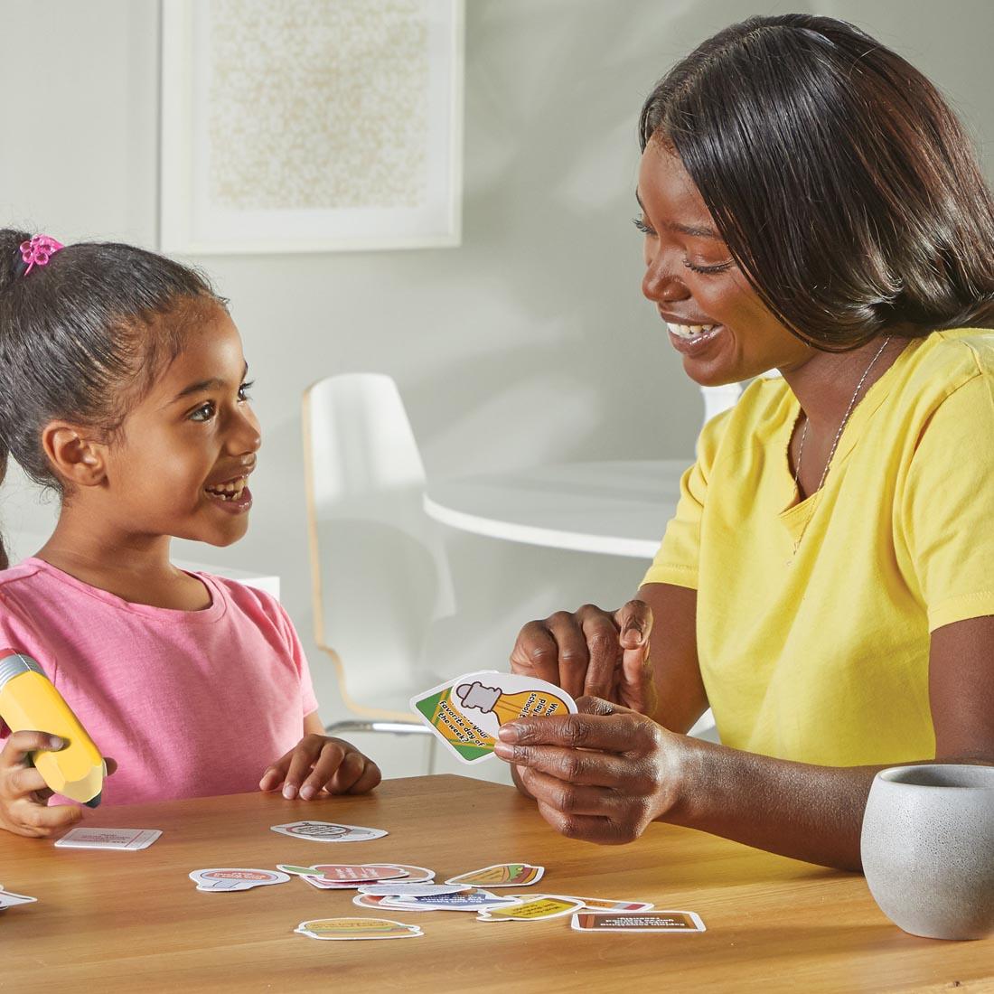 child and adult looking at cards from the Unpack Your Day Conversation Kit By Learning Resources
