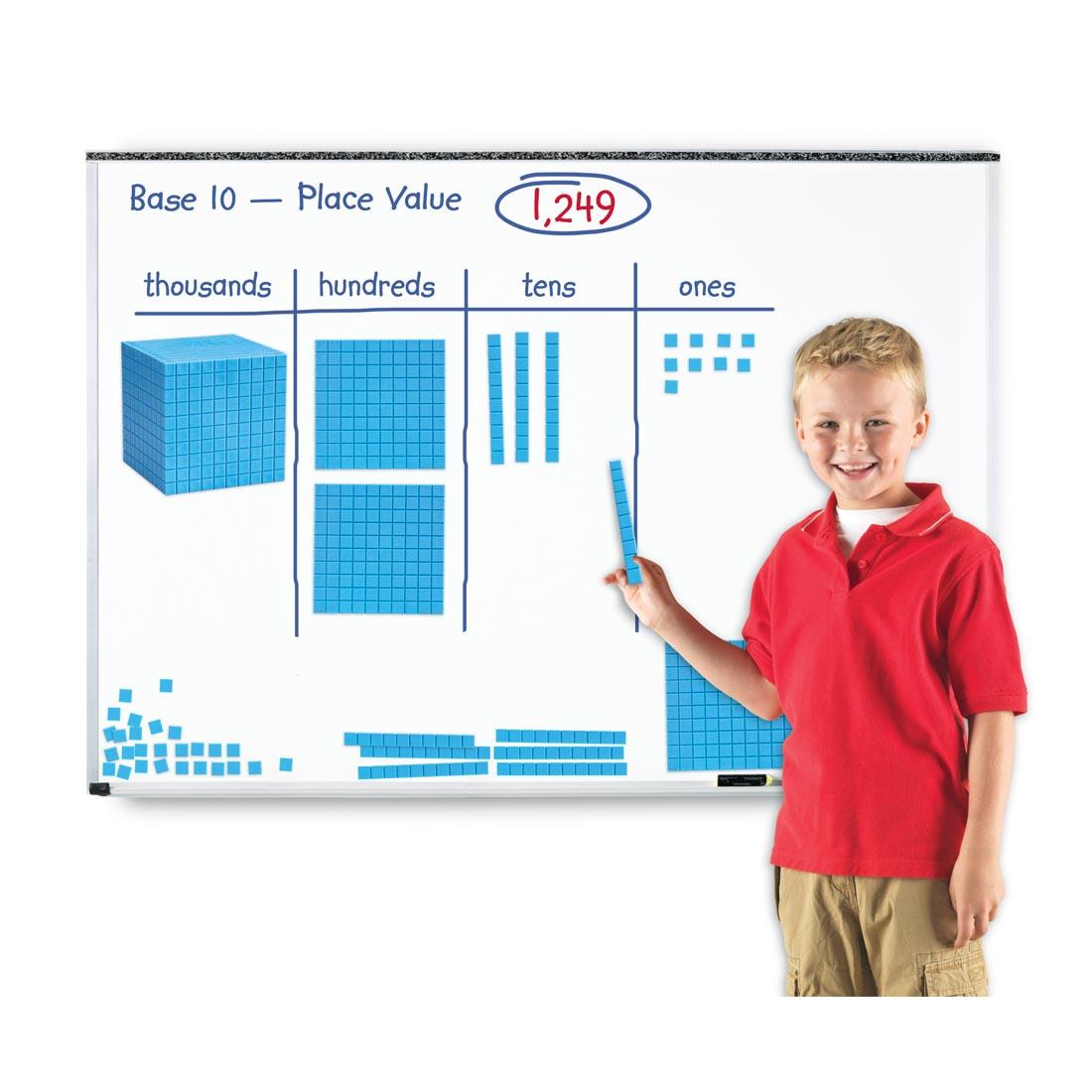 child standing at a whiteboard with the Giant Magnetic Base Ten Set attached