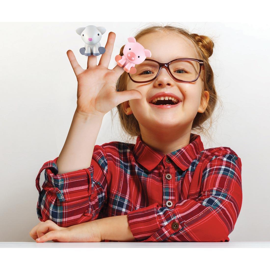 child with sheep and pig finger puppets on hand