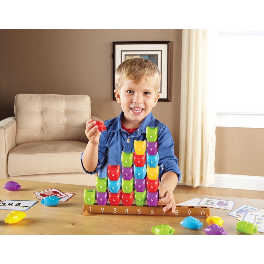 child stacking colorful owls on the number rod of 1-10 Counting Owls Activity Set