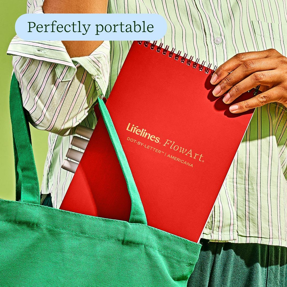 hand putting a FlowArt Dot-By-Letter Americana by Lifelines book in a tote plus text Perfectly portable