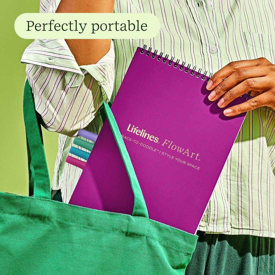 close up of a hand putting FlowArt Trace-To-Doodle Style Your Space pad by Lifelines in a bag, with the words: Perfectly portable