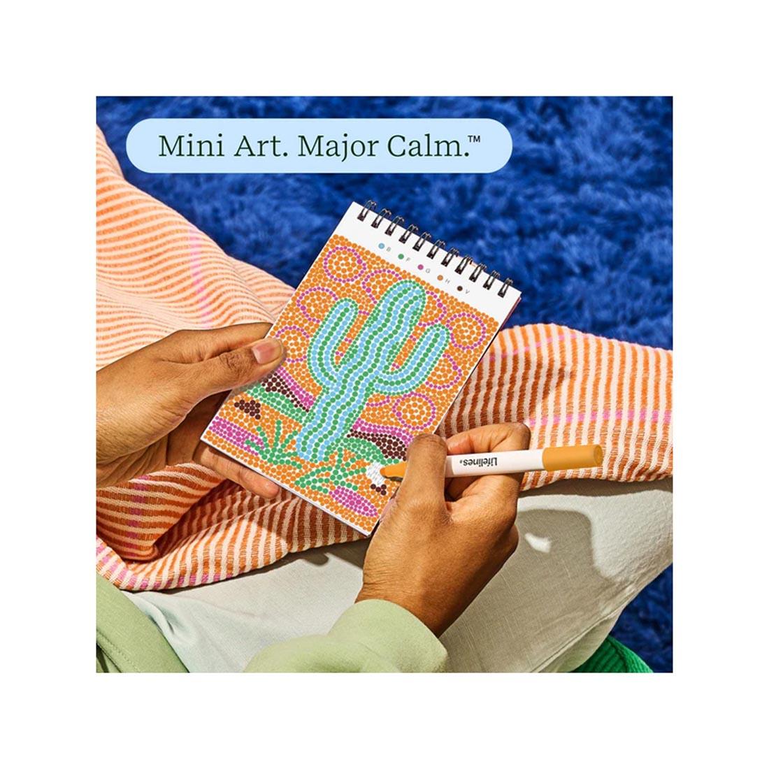 hands working on completing an image in Nature's Wonders Mini Dot-By-Letter FlowArt by Lifelines plus text Mini Art. Major Calm.