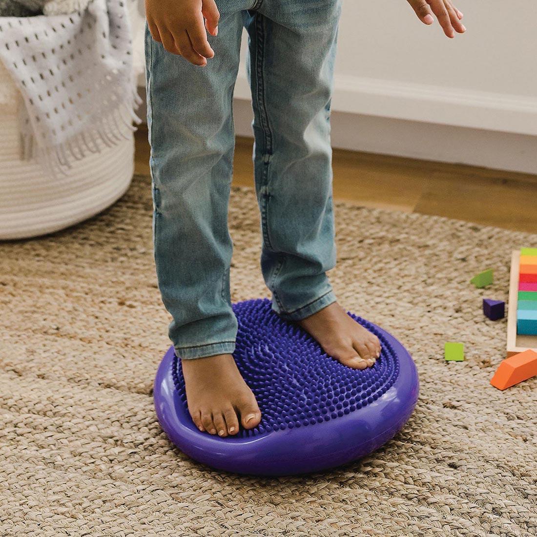 child's feet standing on the Sensory Genius Wobble Cushion By Mindware