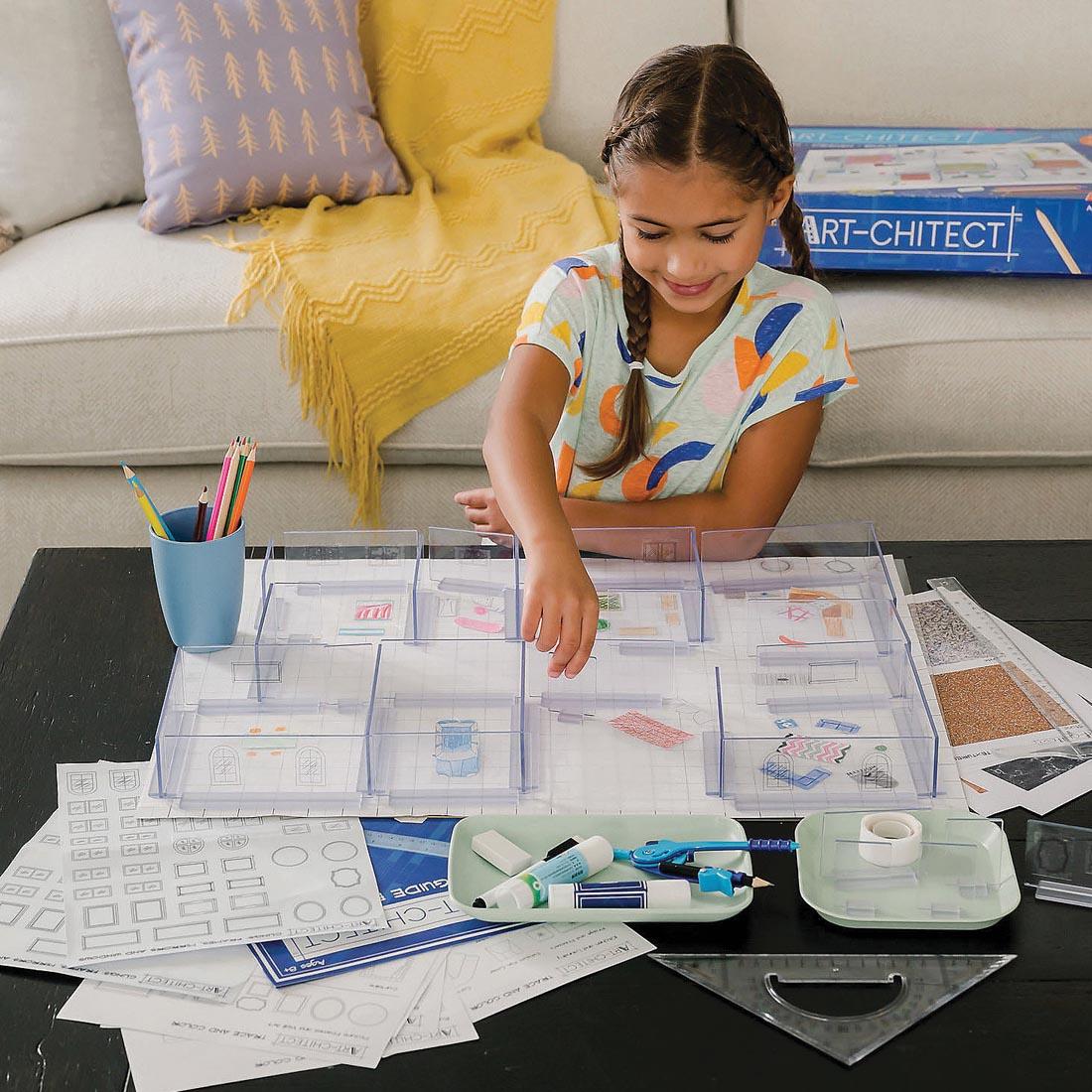 child at a table using the Art-chitect 3-D Home Design Architecture Kit