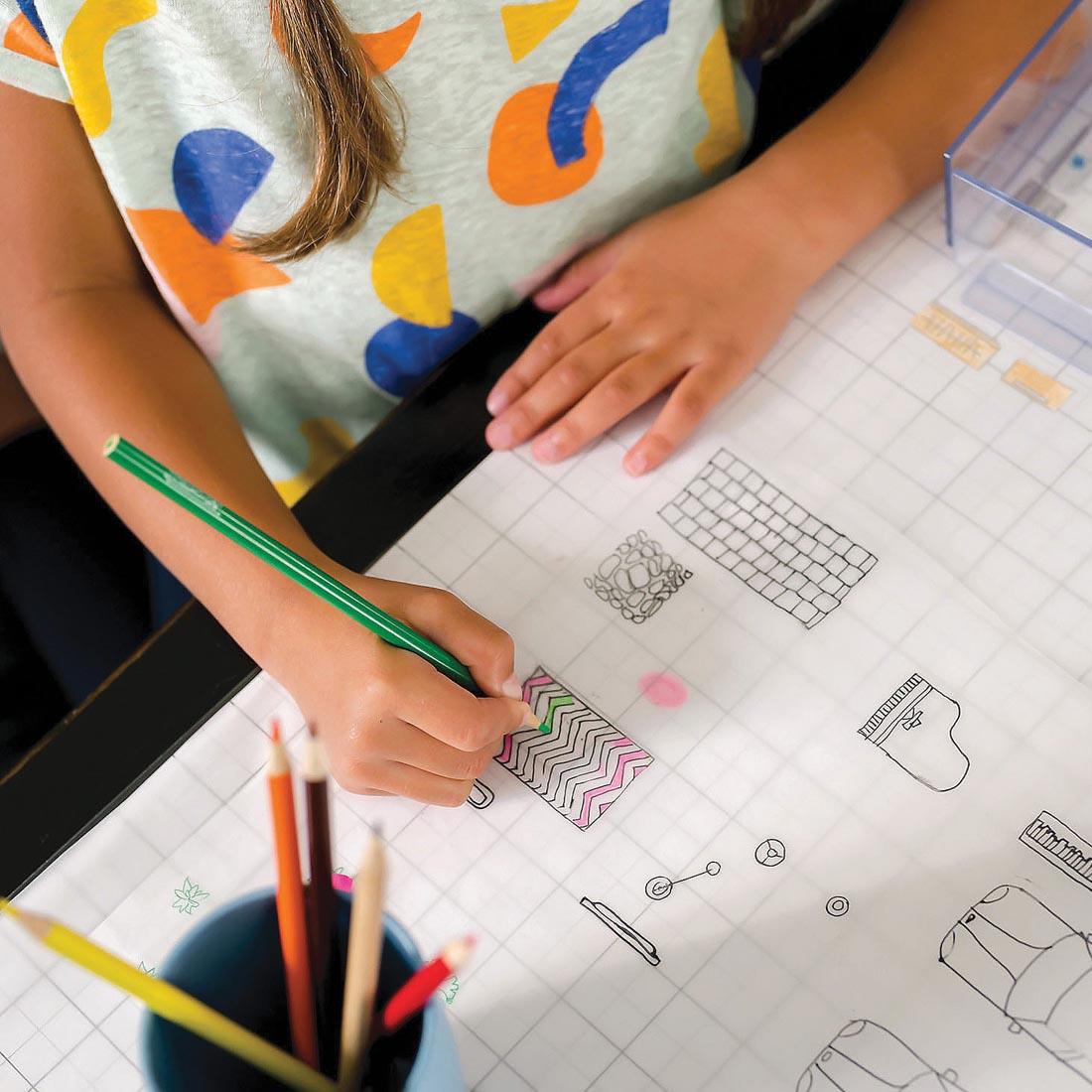 child's hands coloring in a design on the Art-chitect 3-D Home Design Architecture Kit