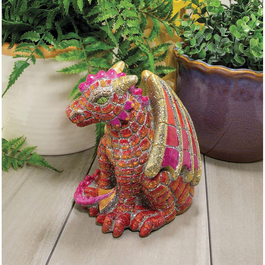 completed example of Paint Your Own Stone Dragon sitting near plants