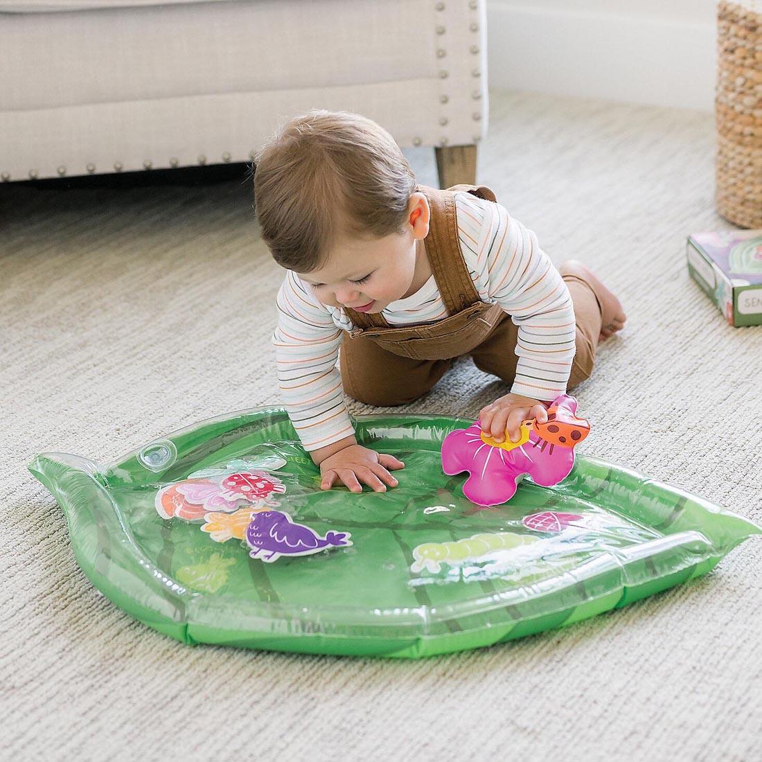 baby on floor playing with the Sensory Sprouts Baby Water Mat By Mindware