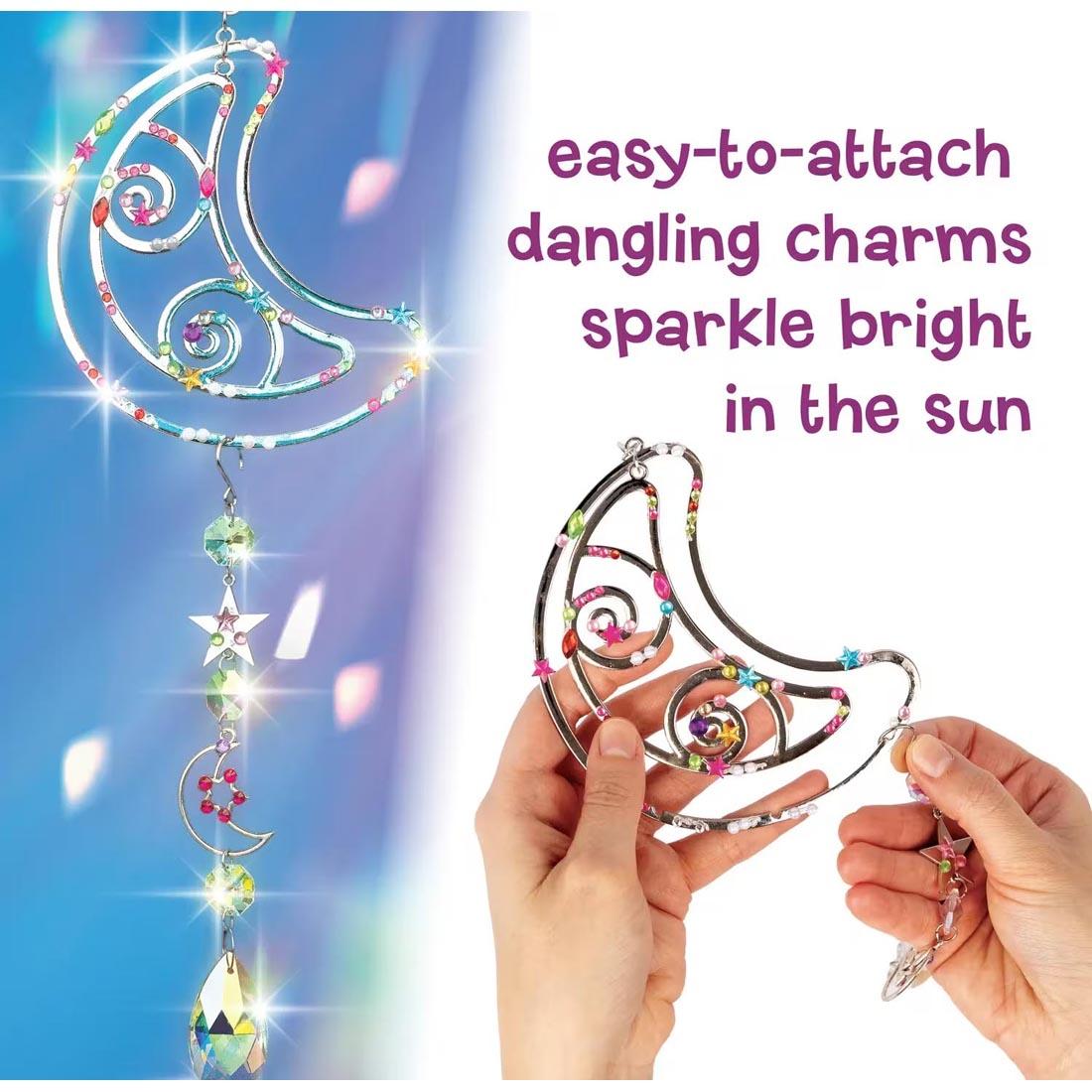 completed project from the Make Your Own Suncatcher Kit By Mindware plus hands holding one and text easy-to-attach dangling charms sparkle bright in the sun