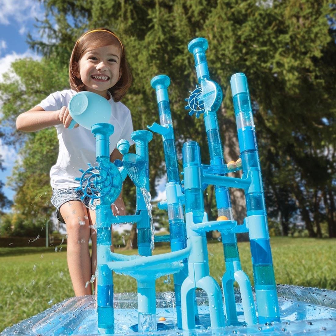 child outdoors playing with the Aqua Maze Twist Water Marble Run