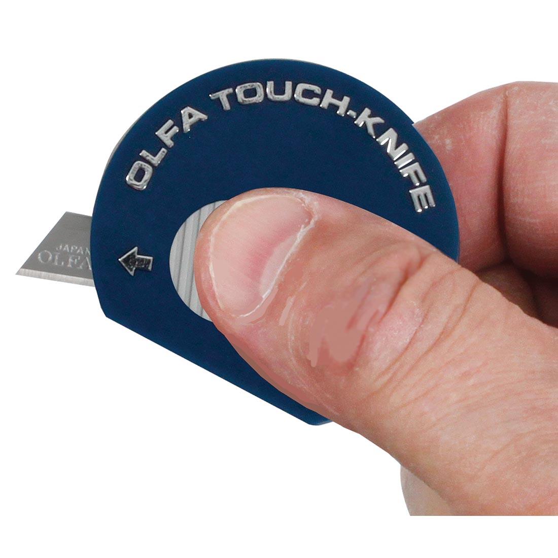 Olfa touch knife in user's hand, with knife blade exposed