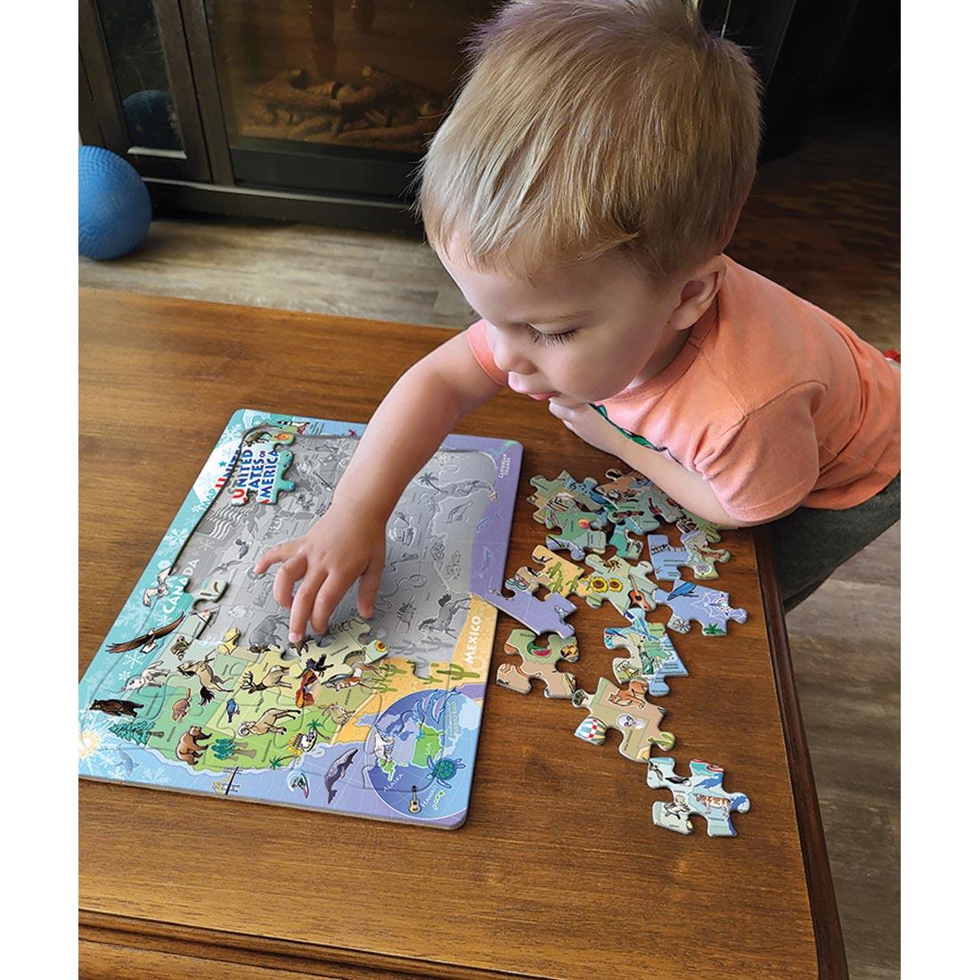 child playing with the Map Of the United States Of America 35-Piece Tray Puzzle By Cobble Hill