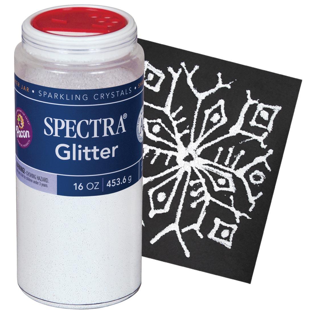 Jar of White Spectra Glitter Sparkling Crystals next to sample snowflake made with them