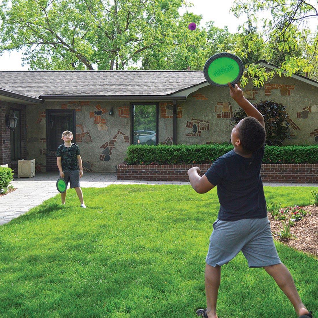 outdoor scene with two children playing with the Koosh Paddle Play Set