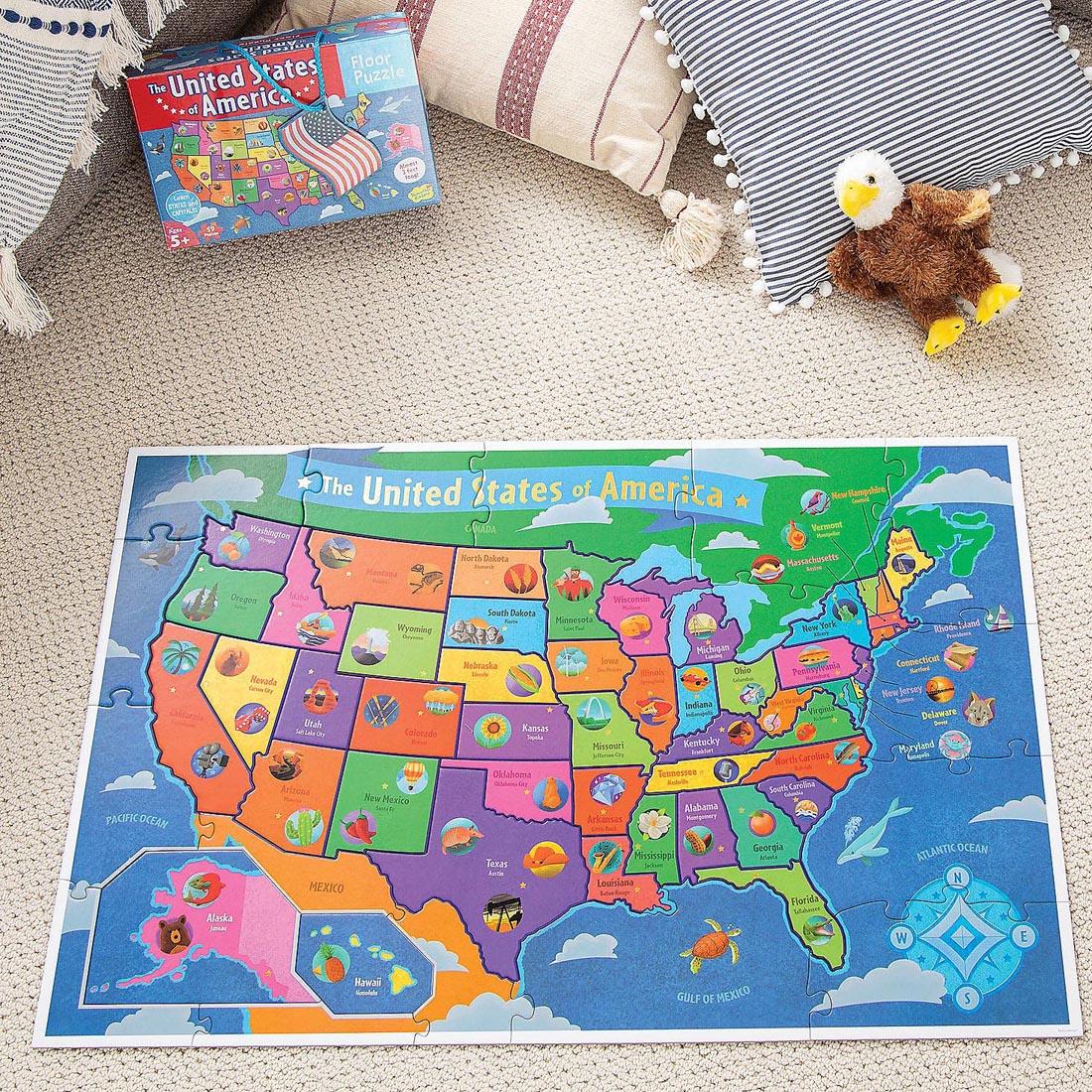 completed 54-Piece USA Floor Puzzle By Peaceable Kingdom beside its box