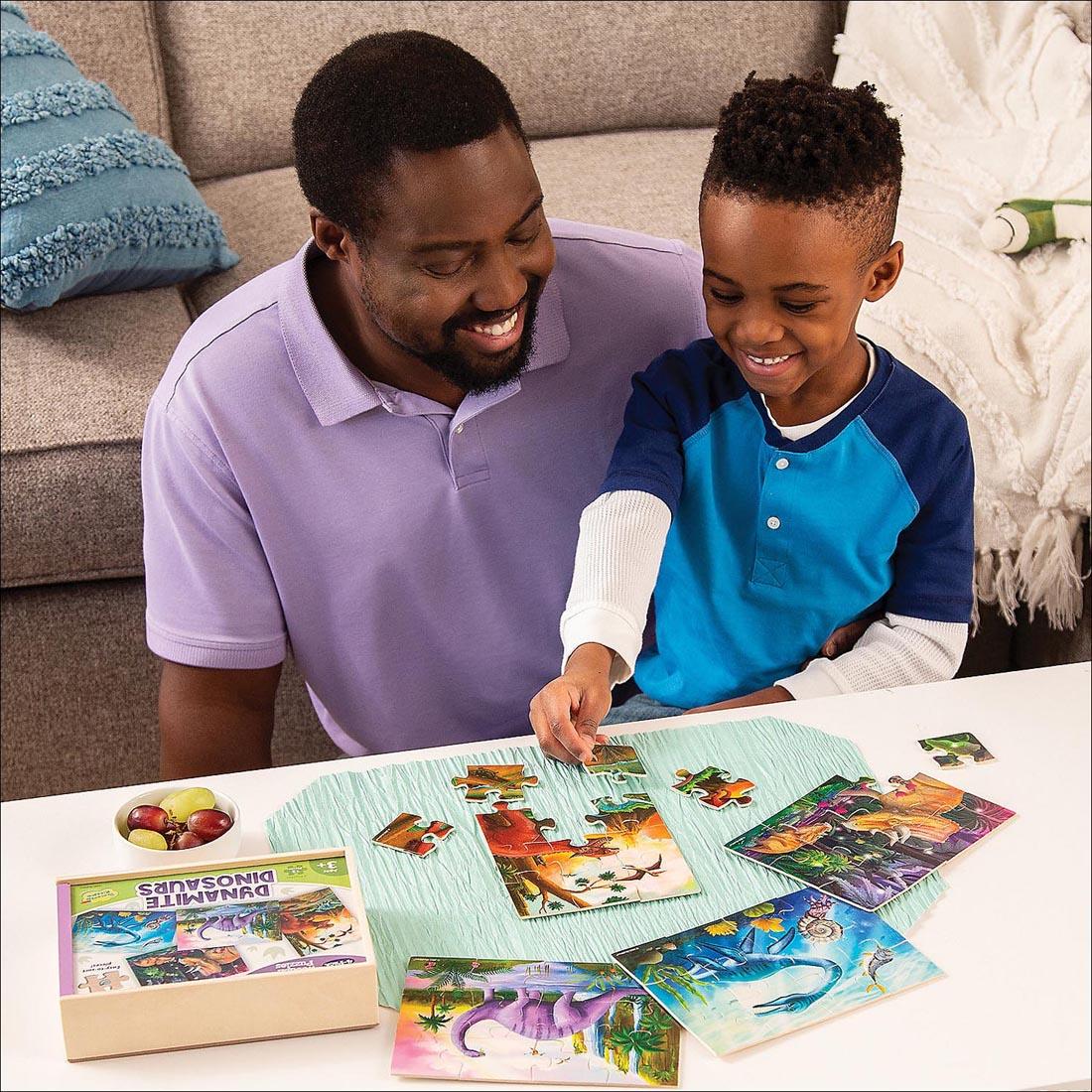 child with adult completing puzzles from the Dynamite Dinosaurs Wooden Puzzles 4-Pack By Peaceable Kingdom