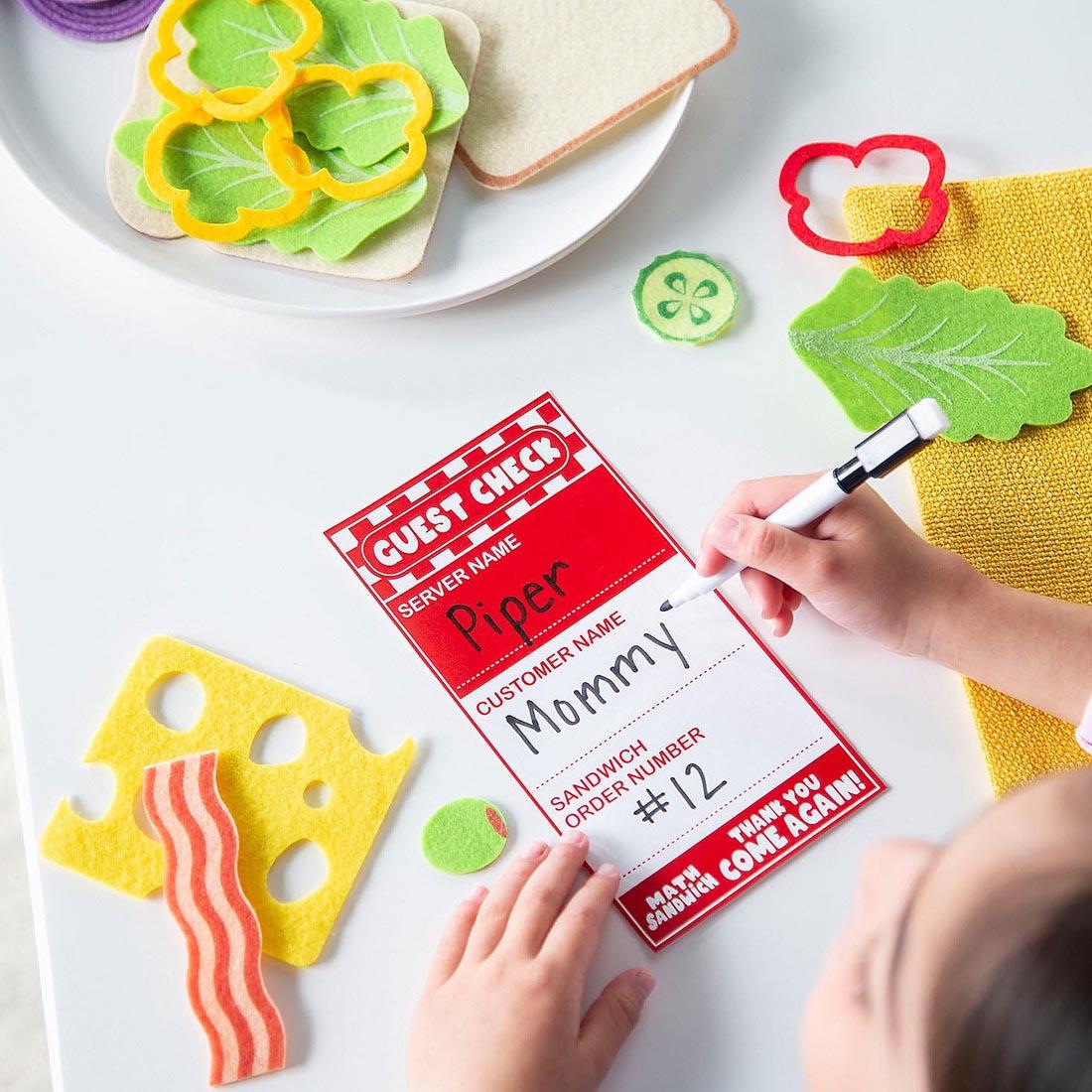 child using pieces from the Math Sandwich Preschool Math Game By Peaceable Kingdom