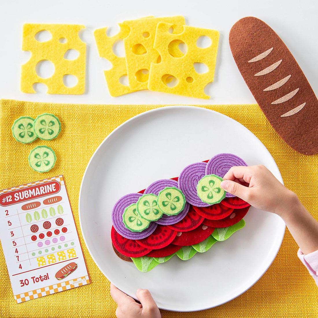 hands assembling a submarine from the Math Sandwich Preschool Math Game By Peaceable Kingdom