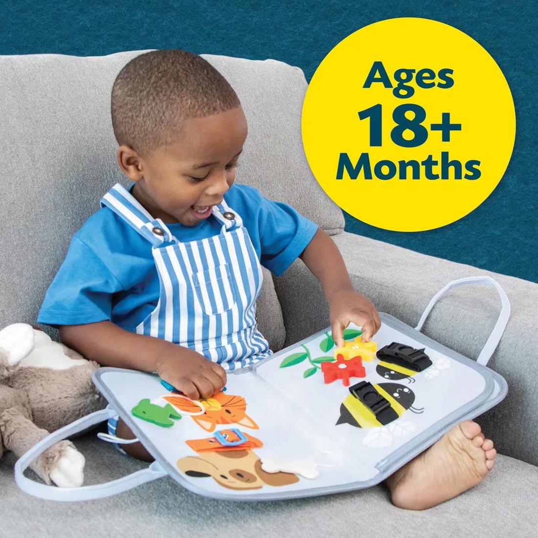child playing with My Busy Tote By Peaceable Kingdom plus text Ages 18+ Months