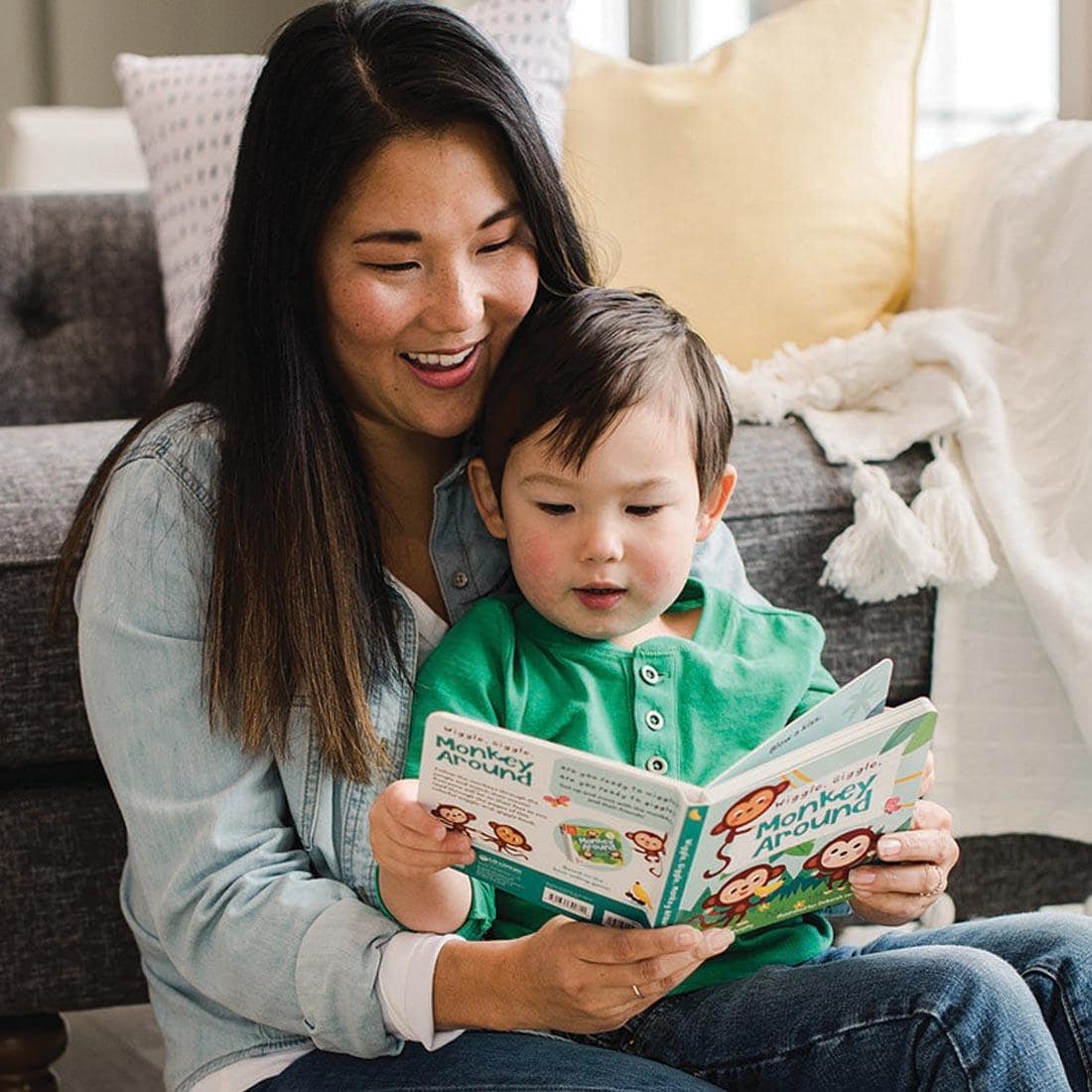 Adult reading the book Wiggle, Giggle, Monkey Around to a child