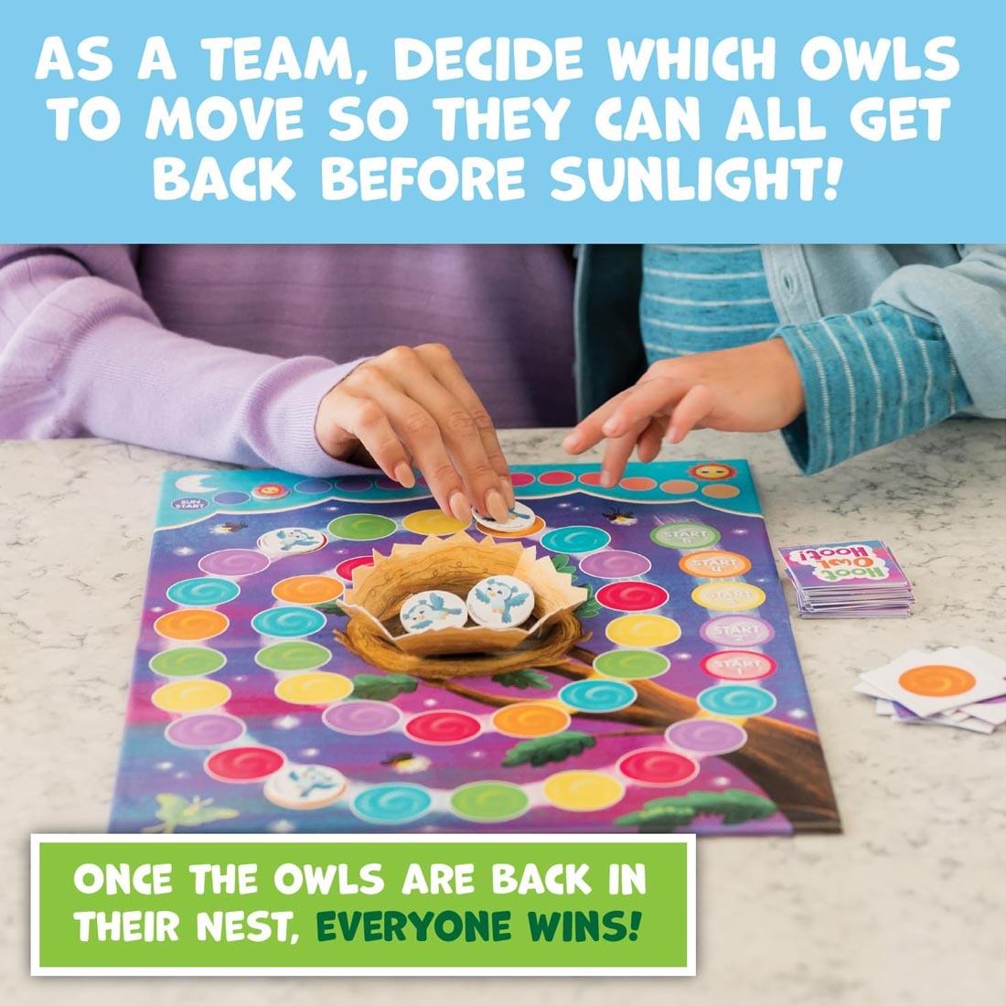 hands playing Hoot Owl Hoot! Cooperative Board Game plus text As a team, decide which owls to move so they can all get back before sunlight! Once the owls are back in their nest, everyone wins!